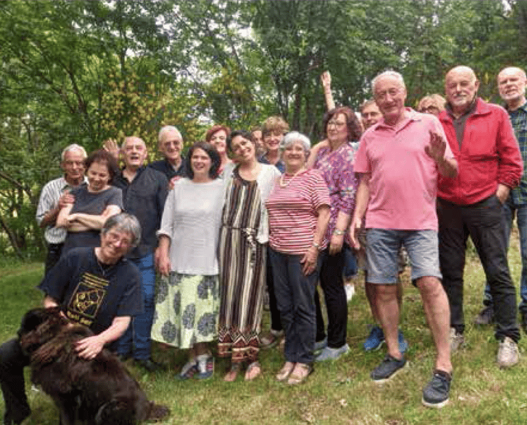 a group of people standing in a field with a dog