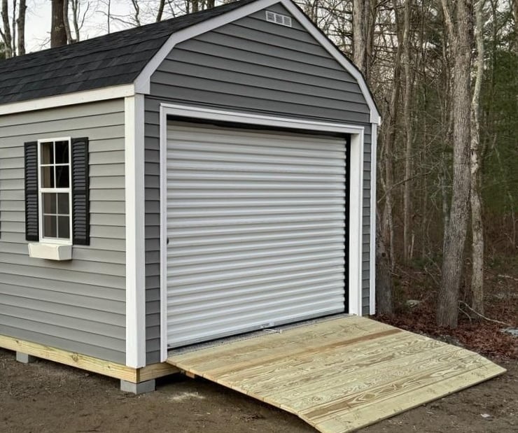 Custom shed with roll-up garage door built in Massachusetts for versatile storage solutions.