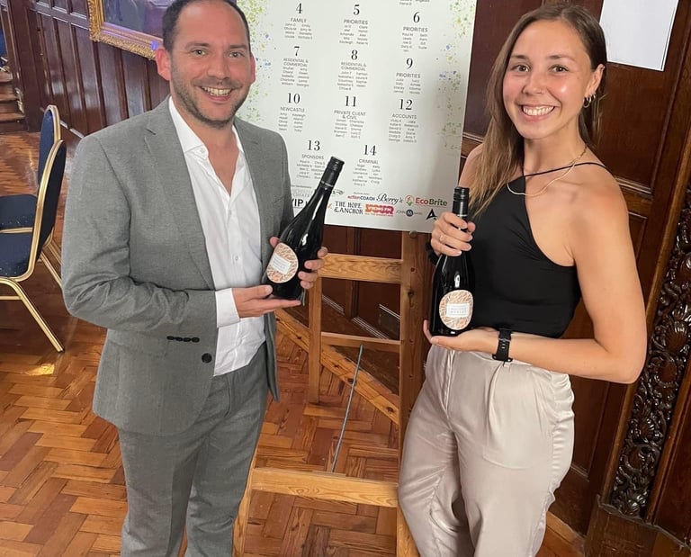 Alex Duffy and Nicola Lashley holding bottles of Prosecco.