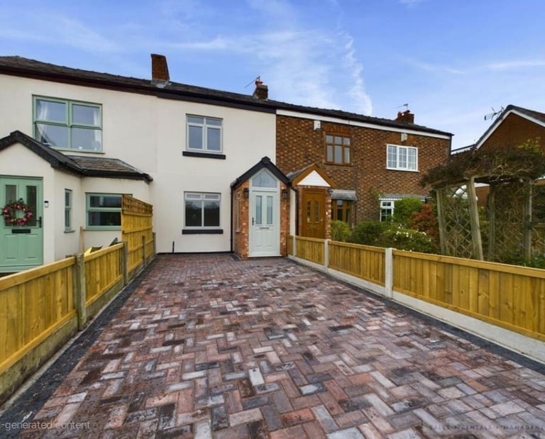 Terraced house featuring a modern block paving driveway and wooden panel fencing.