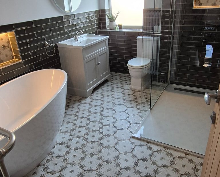 Modern bathroom featuring patterned floor tiles, a freestanding bathtub, and walk-in glass shower.