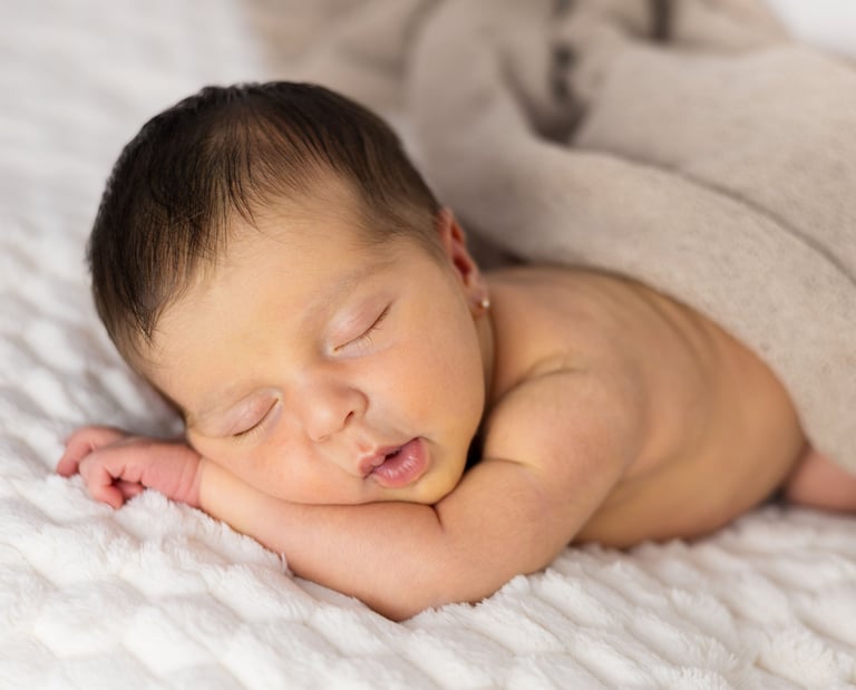 Sessió de fotos newborn a Girona amb una bebè recent nascuda dormint en estudi fotogràfic