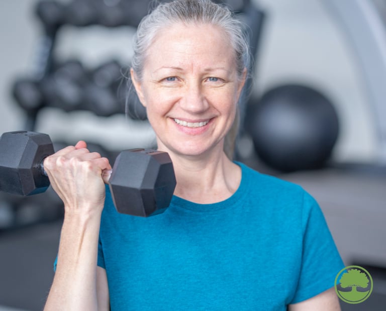 a woman in a blue shirt is holding a dumbbell