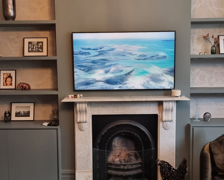 TV wall mounting above an ornate fireplace in Milton Keynes with hidden cables.