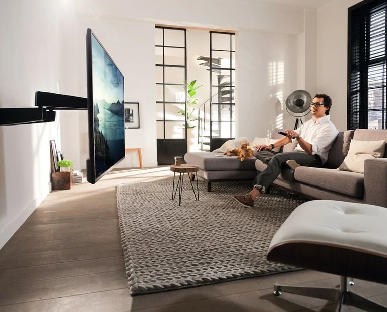 A couple enjoying a movie in a luxury London living room featuring a custom motorised TV mount 