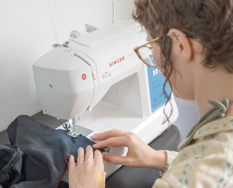 Vu de dos d'une personne cousant sur une machine à coudre