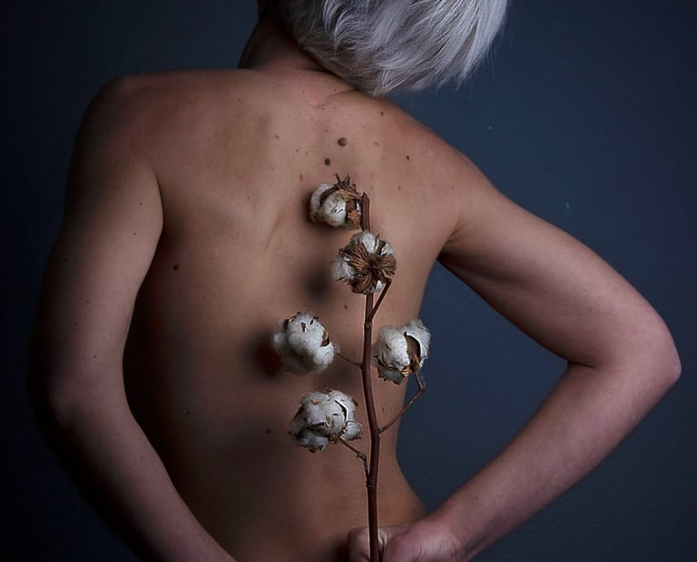 main qui tiennent une fleur sur un dos nu