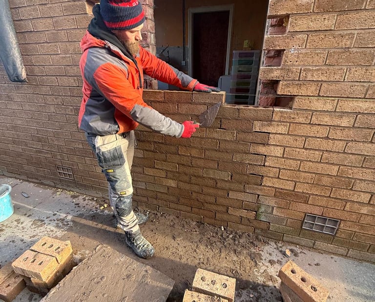 Bricklayer repairing brickwork on residential property in Southport