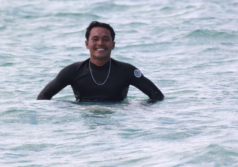 Romi smiling warmly at Paradise Surf School Lombok, embodying the friendly spirit of surfing and instruction.