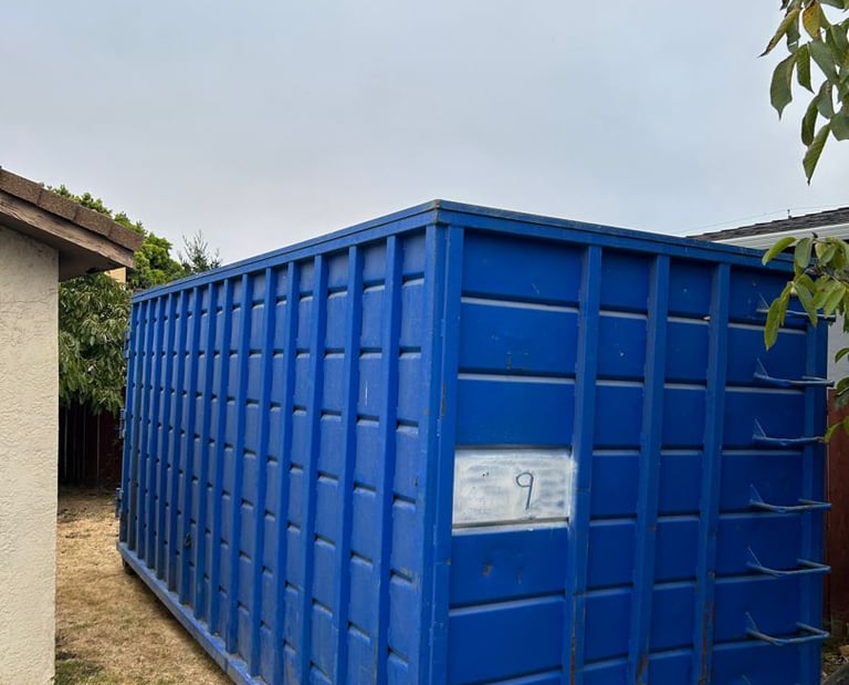 a blue container container sitting on the side of a house