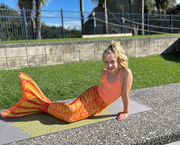 Child in a Mermaid tail learning to swim