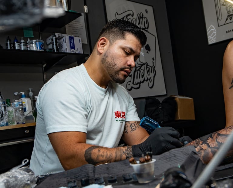 Junior doing a leg sleeve tattoo at royal nine tattoo