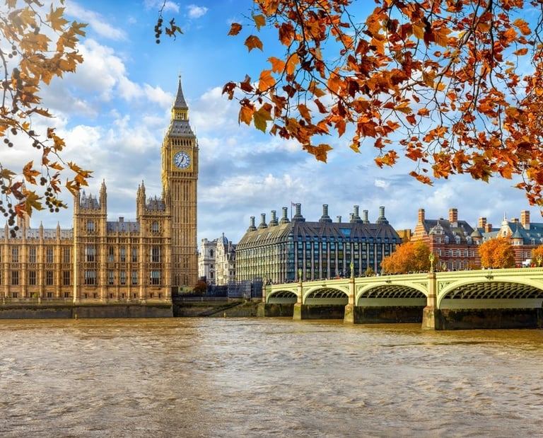 a bridge over a river with a clock tower in the background