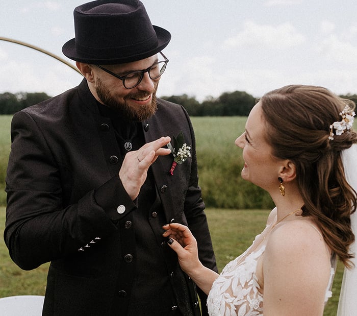 das alternative Hochzeitspaar strahlt sich nach dem Einzug an. der Bräutigam zeigt ihr, wie toll er ihren Style findet