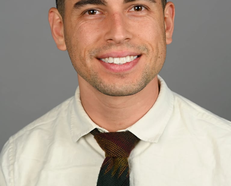 Daniel Alvarez in a cream shirt and tie 