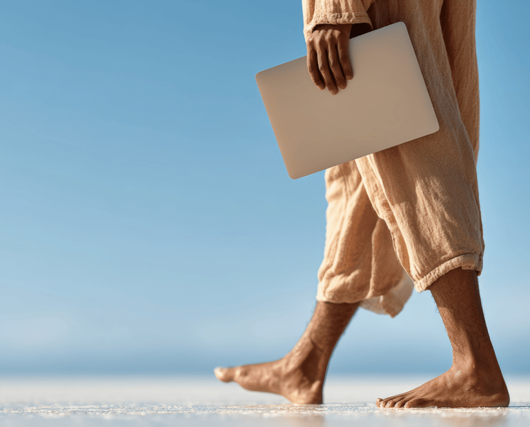 a man walking on the beach with a laptop