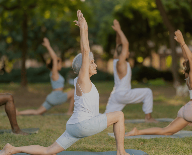 a group of people doing yoga poses in a park
