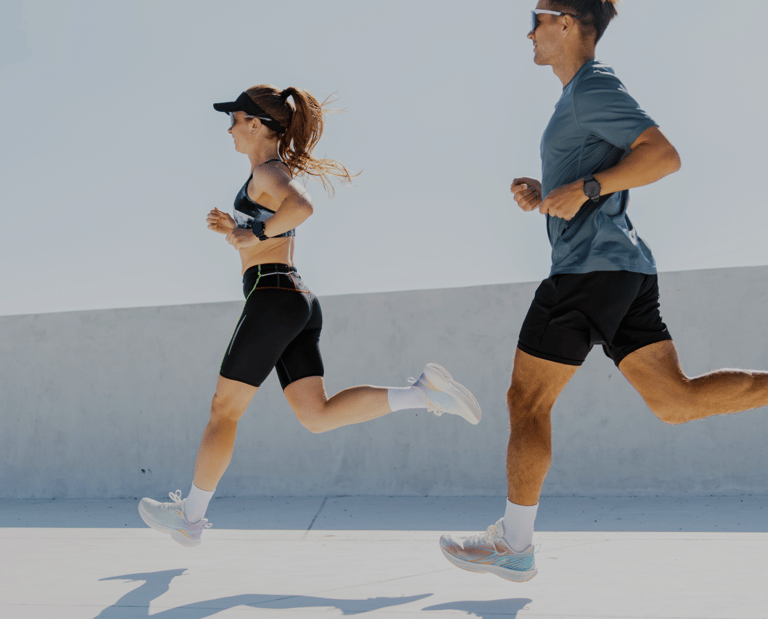 a man and woman running in a city