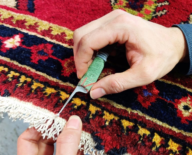 restauratore di tappeti che realizza la chiusura delle frange a uncinetto