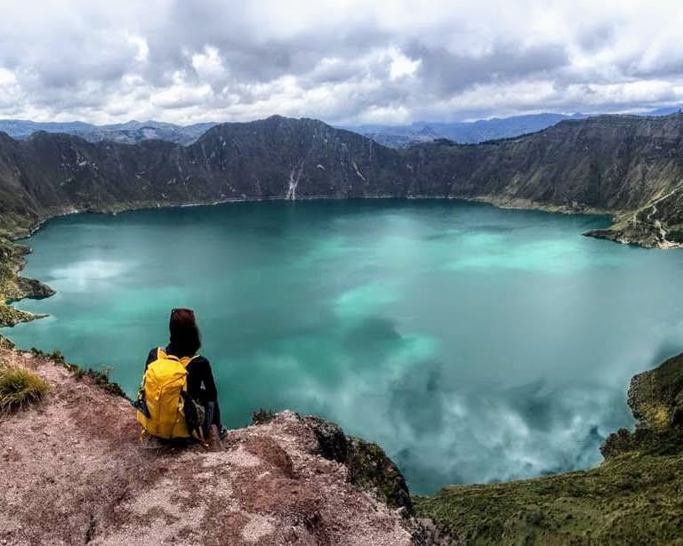 hiker admiring Quilotoa crater lake