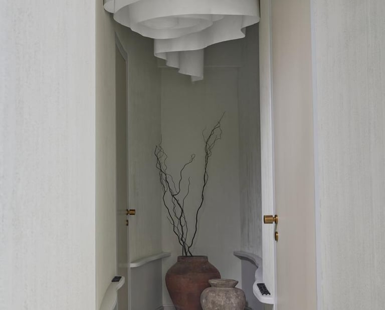 Modern minimalist hallway design with curved walls and artistic ceiling installation