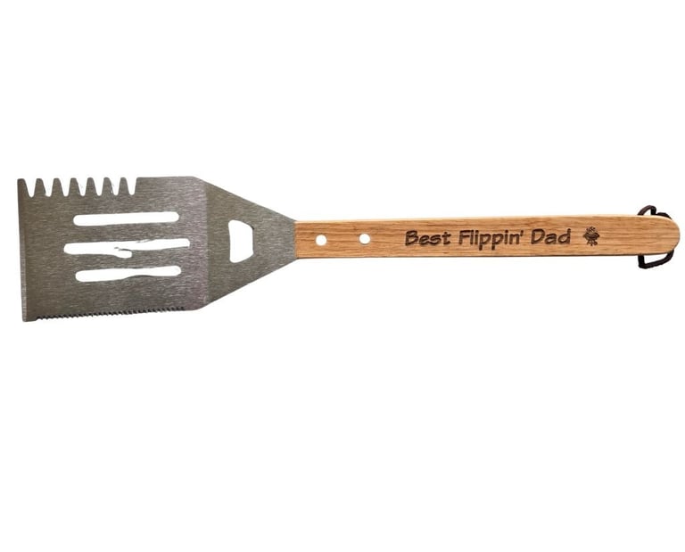 A outdoor grill spatula that has best flippin' dad engraved on the handle