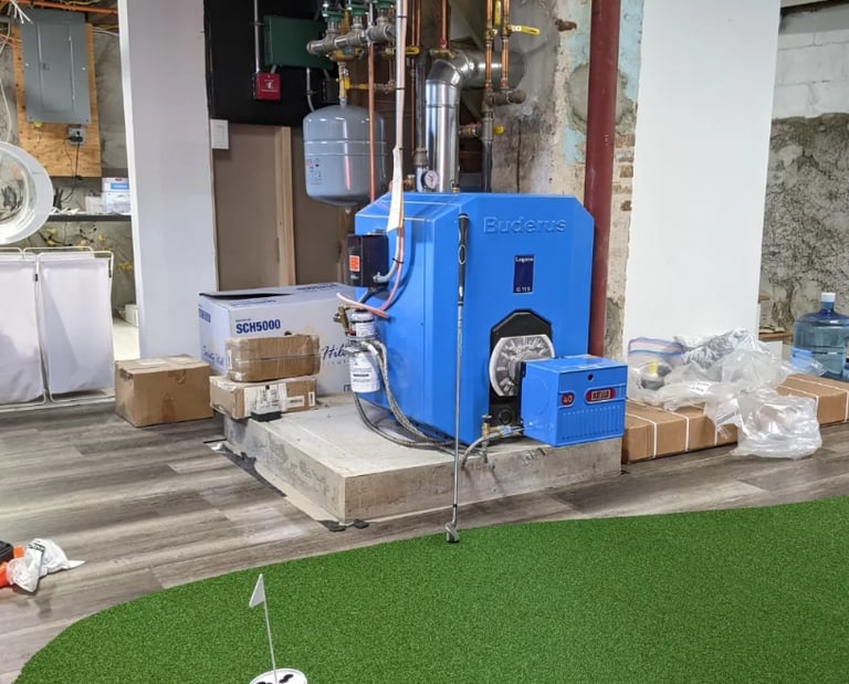 Buderus blue oil boiler system installed in a basement next to an indoor putting green.