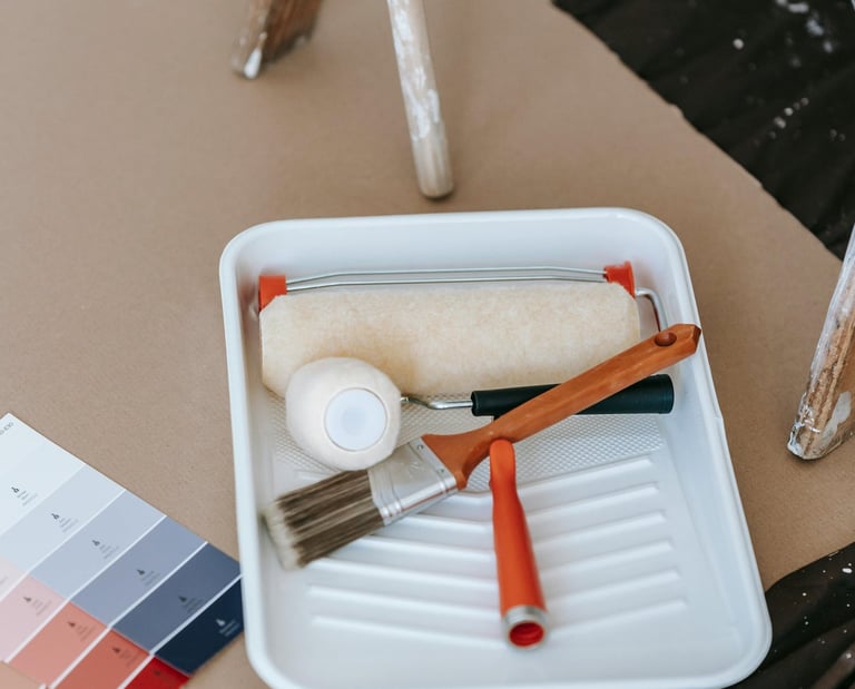 a paint roller brush and paint brushes on a table