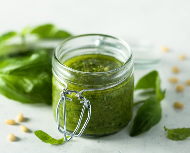 Recipiente de vidrio con pesto artesanal de albahaca hidropónica