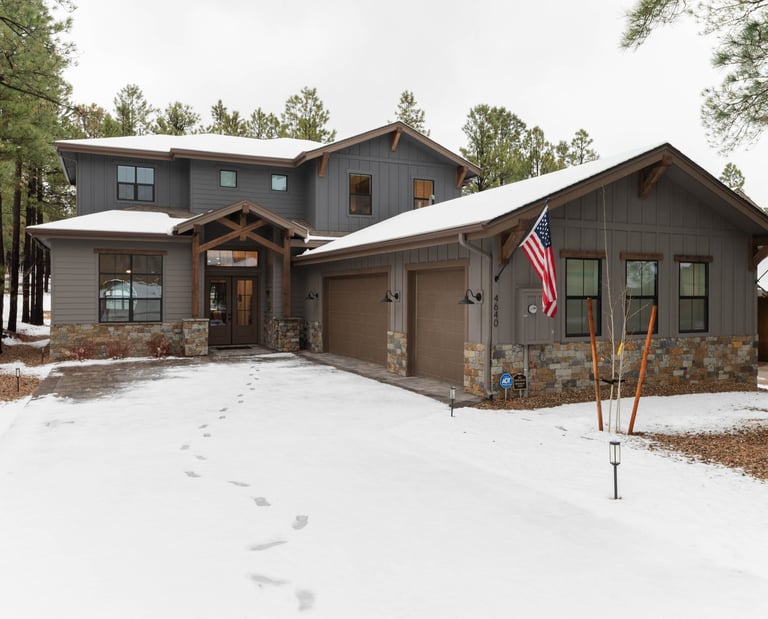 custom home with large garage and snowy driveway