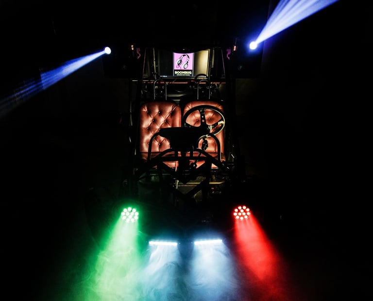 Custom Mobile Dj buggy with colorful LED light show and fog machine in a dark garage.