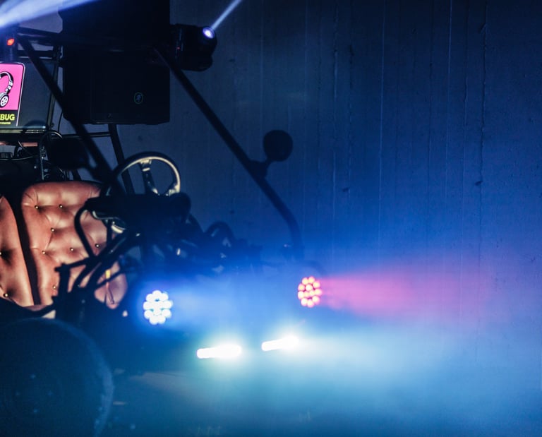 Custom Boombug party camper with stage lights and DJ equipment in a dark, atmospheric venue.