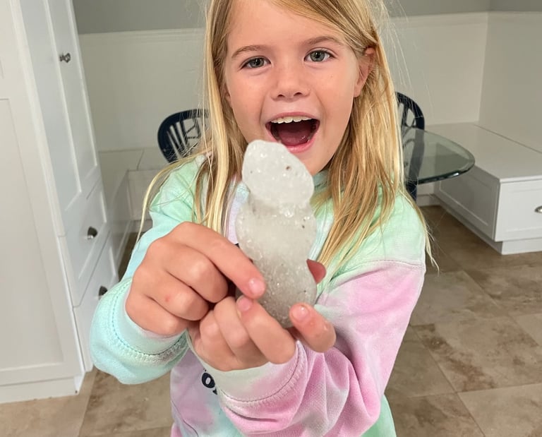 Mary Grace holding a snowman with a big smile on her face