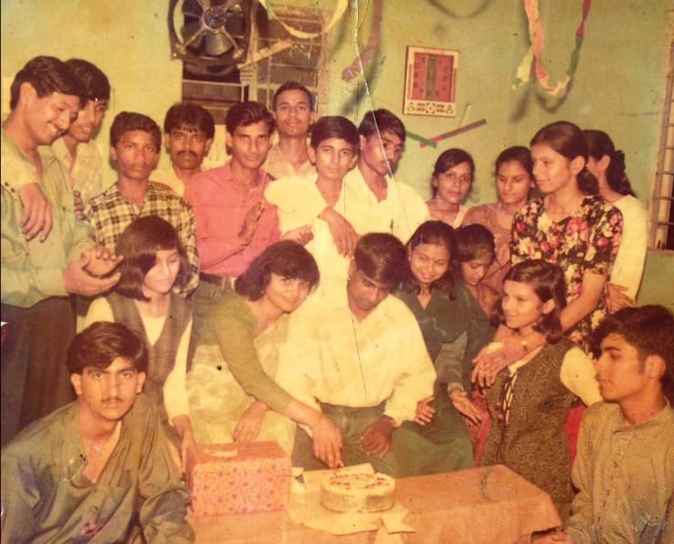 a group of people standing around a table