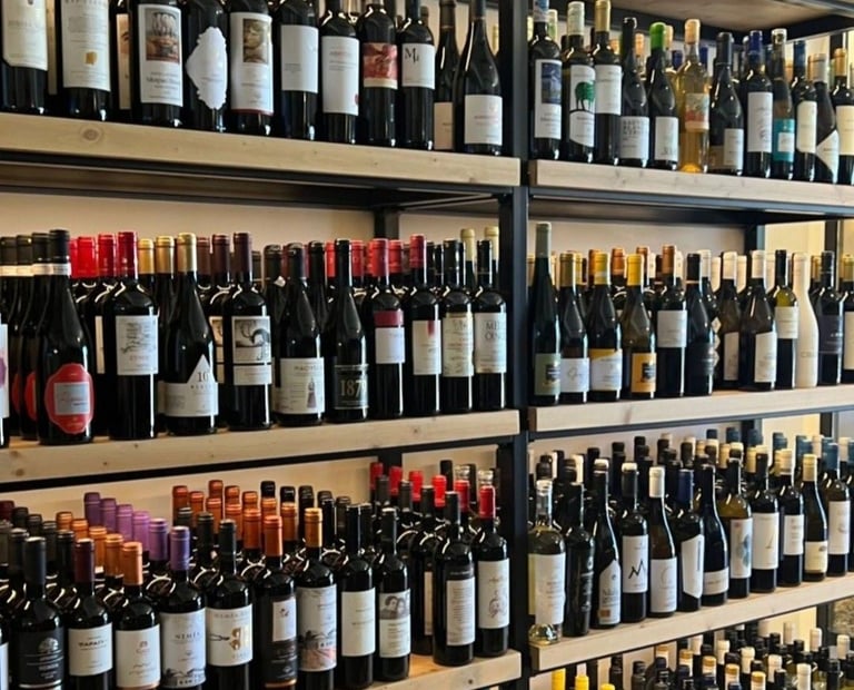 A wide variety of wine bottles displayed on wooden shelves at a wine shop