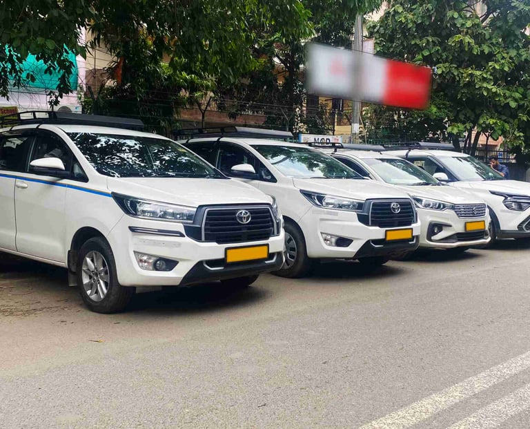 A row of white Toyota Innova Crysta taxis parked on a city street for commercial rental services.