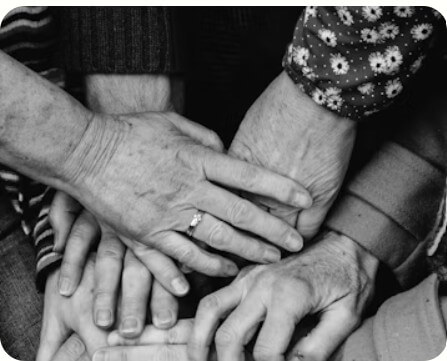 Menschen unterschiedlichen Alters bringen ihre Hände zusammen, was für familiäre Verbundenheit steht