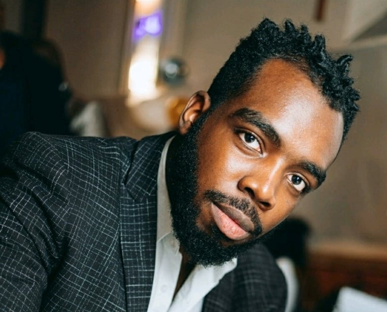 a man in a suit and tie is looking at the camera