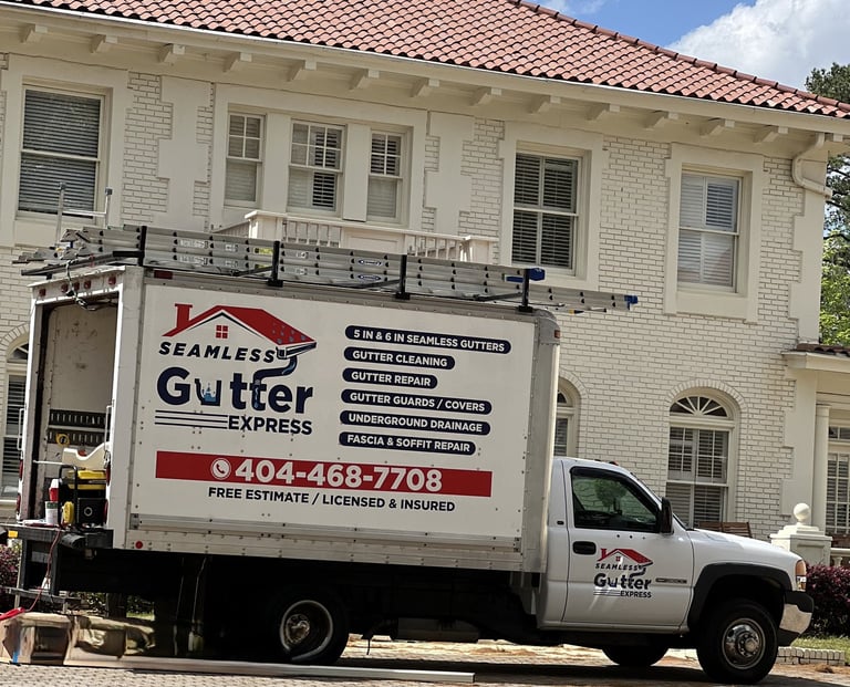 Work truck with Seamless Gutter Express branding parked at a job site.