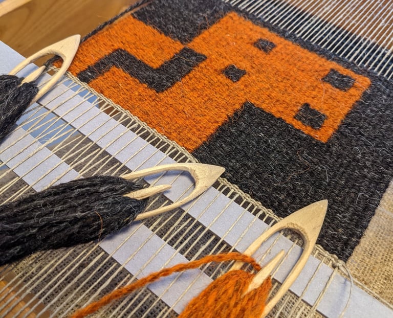 A weaving loom with shuttles and orange, yellow, and black wool threads on a kilim rug with a pixel-