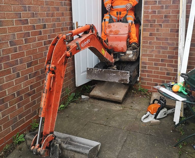 Digger operator preparing foundation for construction site in Oldbury