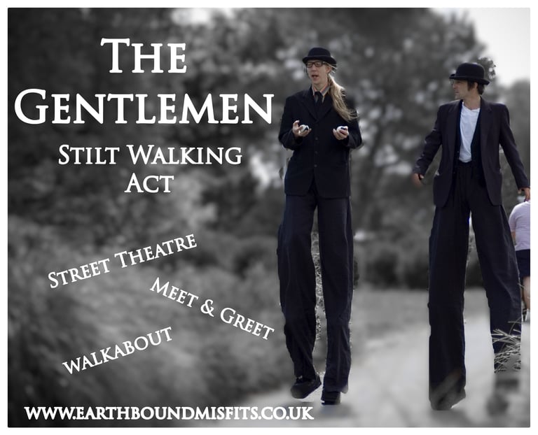 The Gentlemen stilt walking act performing street theatre and walkabout entertainment in black suits.
