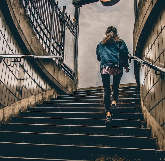A woman engaging in vigorous incidental physical activity by running up a staircase.