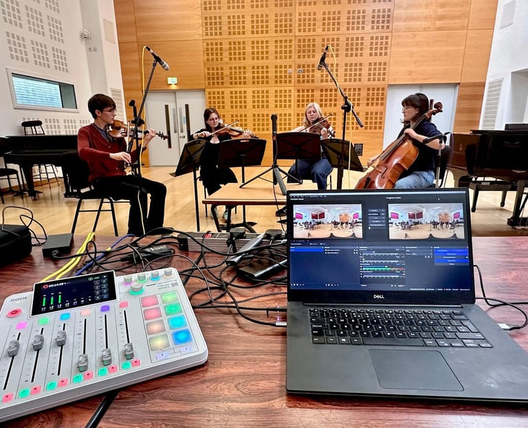 A string quartet recording in a studio with an audio mixer and laptop for live streaming.