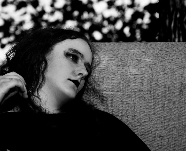 a woman with long hair and a black shirt sitting outdoor