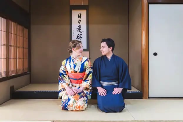 Couple in traditional kimono and hakama sitting in authentic Japanese tatami room
