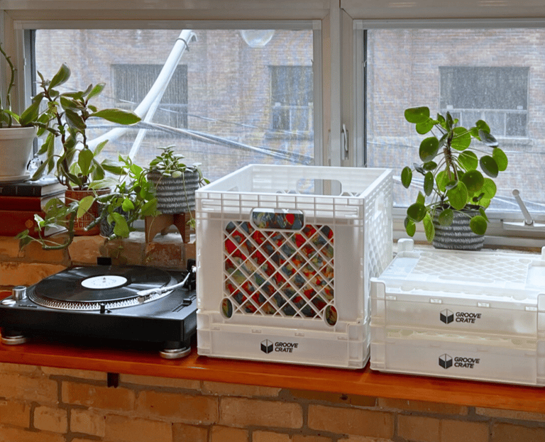 a record player's turntables on a table with a vinyl record storage crate