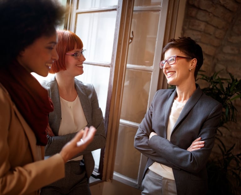 a woman in a suit and glasses talking to a woman