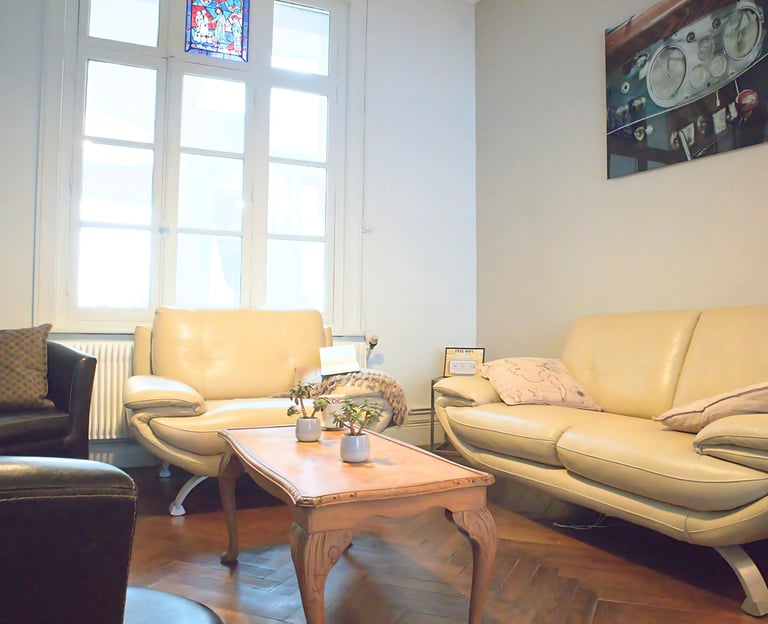 Salon lumineux de logement meublé avec canapés confortables et table basse en bois.