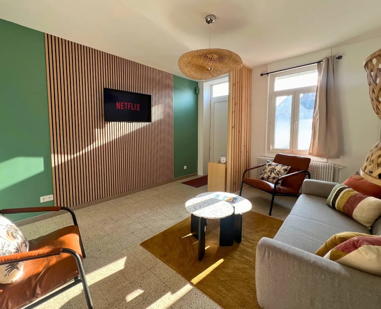 Salon moderne avec TV connectée et canapé, hébergement professionnel tout confort